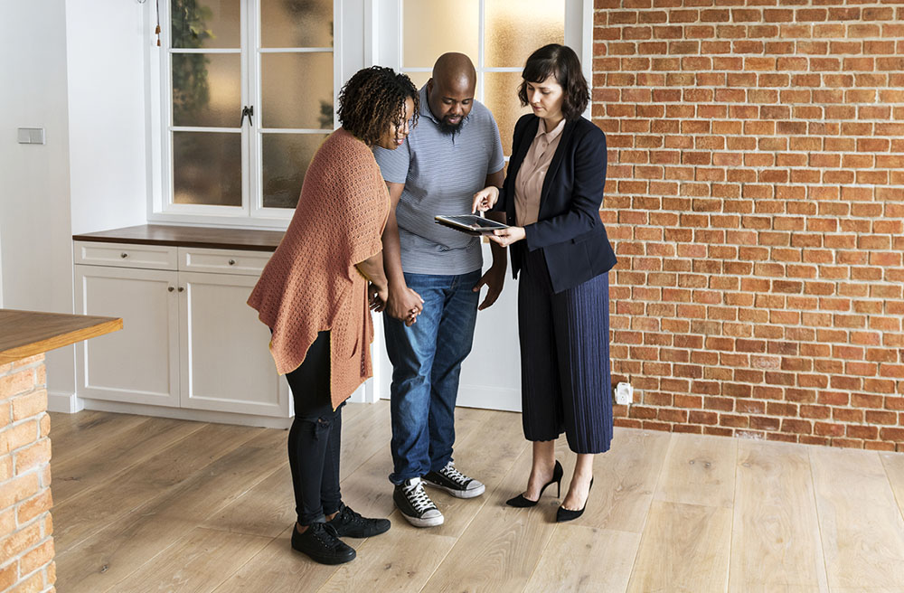 Real estate agent using a tablet to show their clients a digital home inspection report