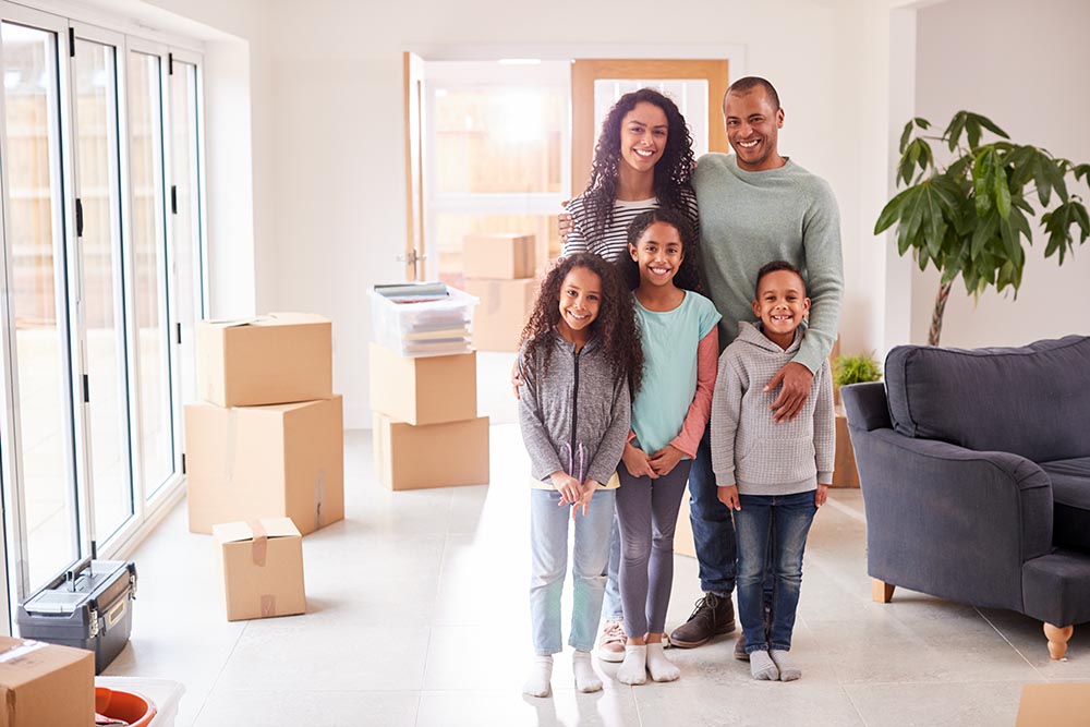 Family of four surrounded by moving boxes in their new house after a home inspection